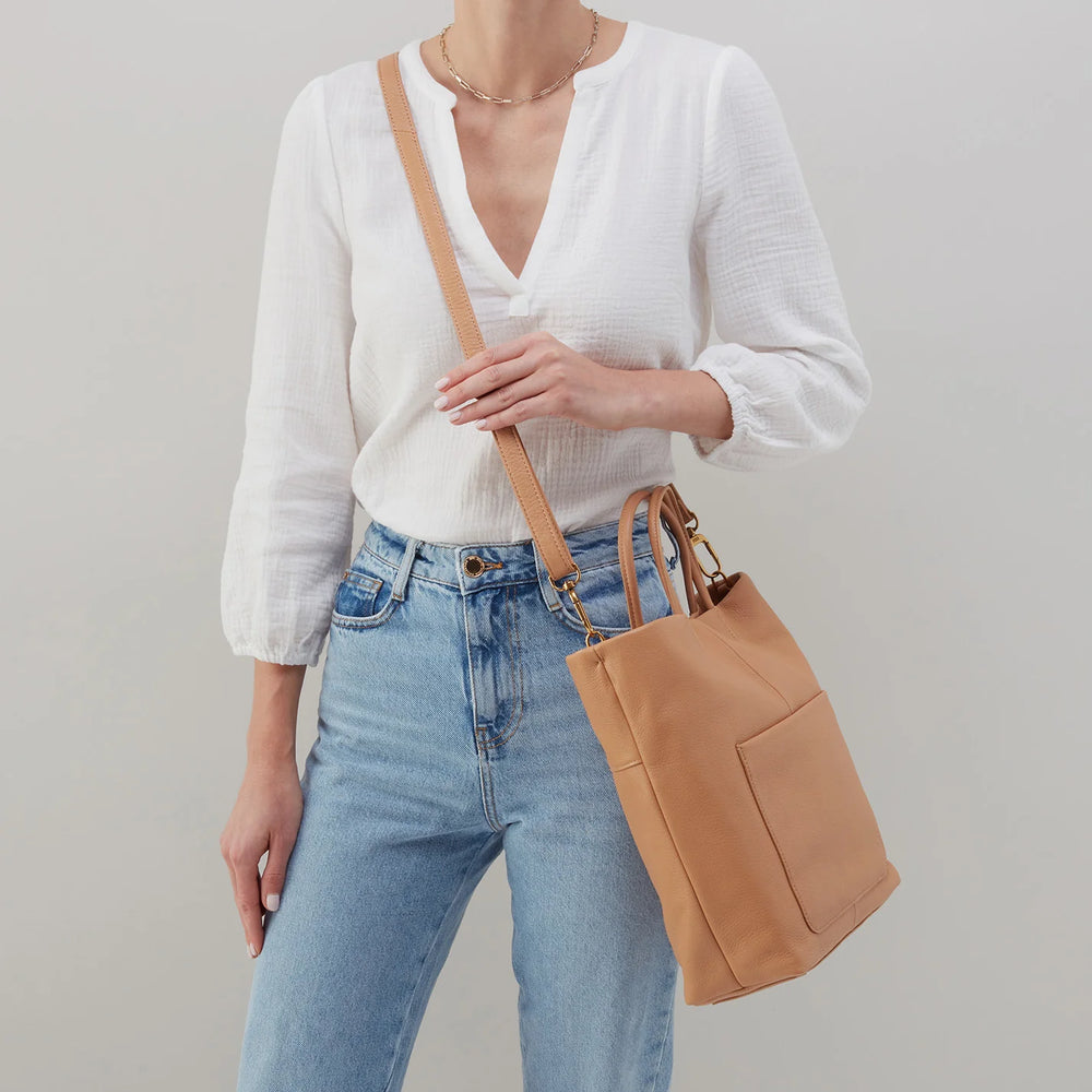 Hobo Bags Tripp Tote in Sandstorm, a stylish accessory with a spacious design and neutral color, perfect for everyday use.