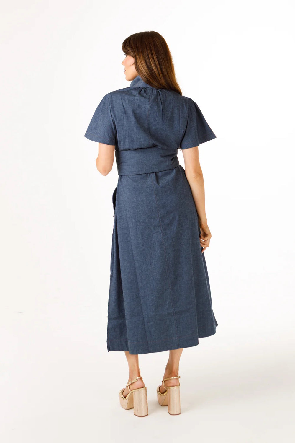 Holly Shae Gretchen denim dress featuring a fitted silhouette and classic blue denim fabric, displayed on a hanger.