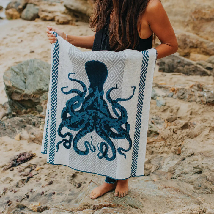 In2Green octopus throw blanket with colorful, soft fabric, draped over a cozy armchair for stylish home decor.