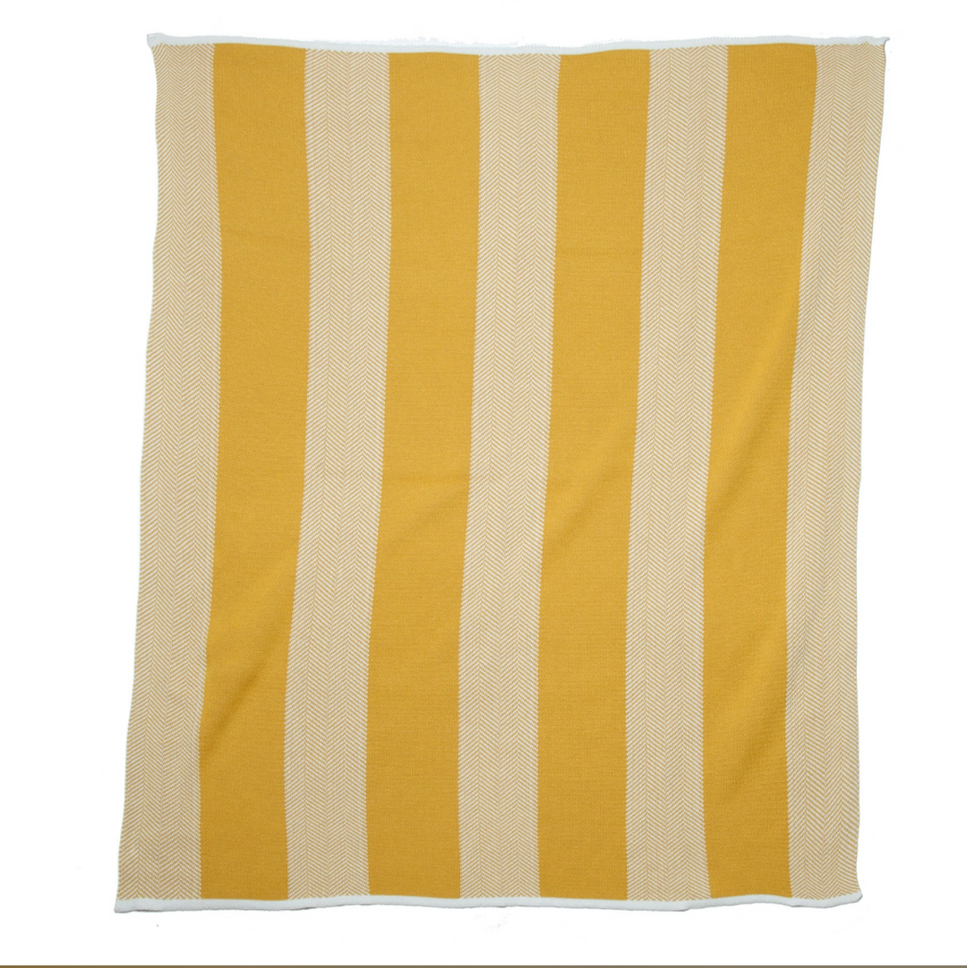 In2Green outdoor herringbone stripe throw blanket with green and neutral tones, displayed on a cozy outdoor setting.