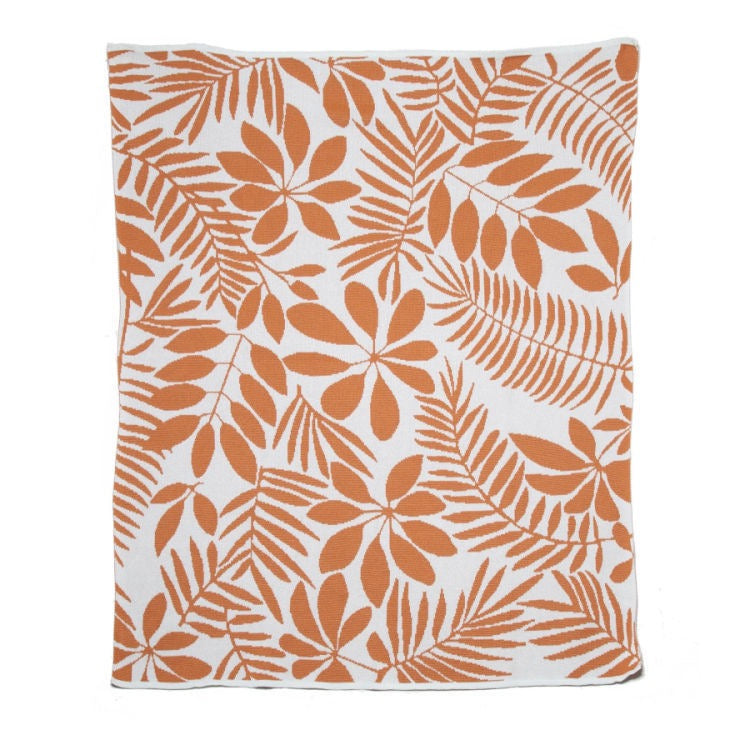 In2Green outdoor eco throw blanket with natural fibers, draped over a patio chair in a garden setting.