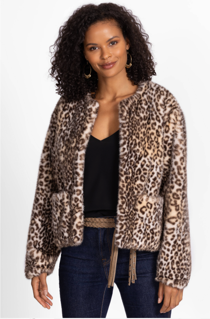 woman wearing a faux fur leopard jacket on a white background

