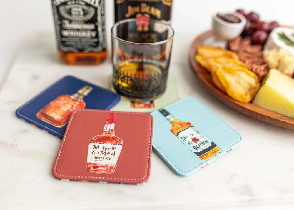 Set of four colorful Keva Style home coasters with vibrant patterns on a wooden table.