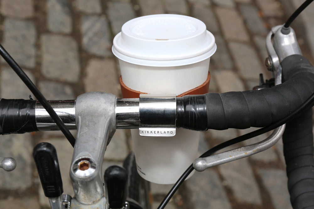 Leather bike cup holder by Kikkerland Design Inc, featuring a compact, durable leather design for holding drinks on a bicycle.