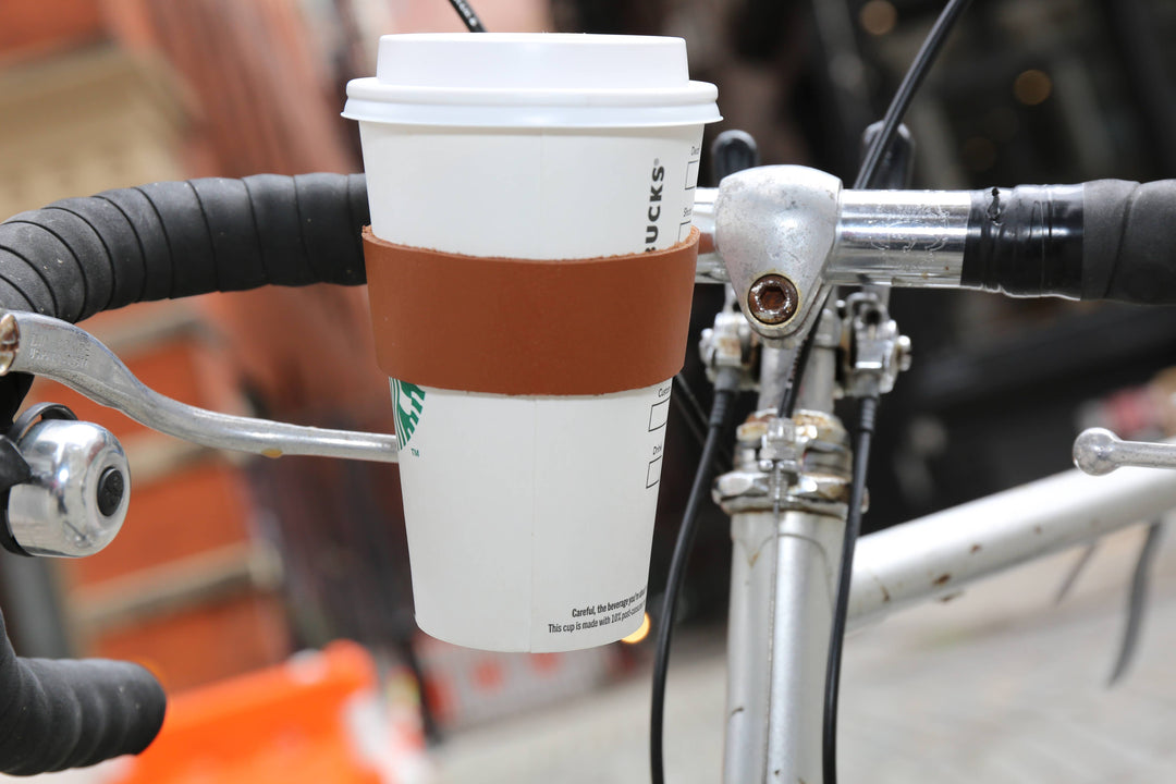 Leather bike cup holder from Kikkerland Design Inc, designed to securely hold beverages on a bicycle.