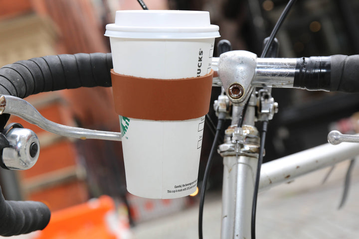 Leather bike cup holder from Kikkerland Design Inc, designed to securely hold beverages on a bicycle.