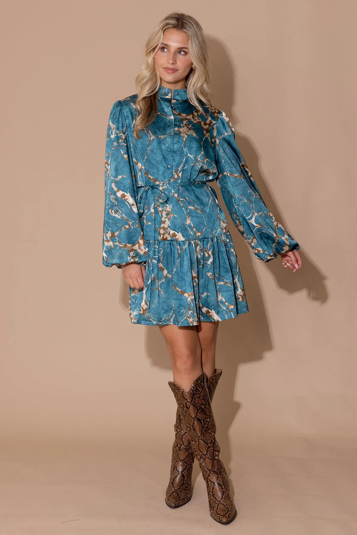 Alden Adair Adele Riverstone Dress displayed on a hanger, featuring a flowy, patterned fabric with a V-neck and long sleeves.