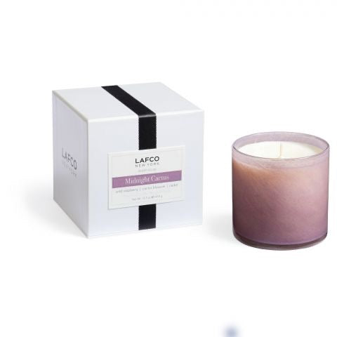 Lafco 15.5oz home candle with a sleek glass container and a lit wick, designed to create a warm, inviting ambiance.