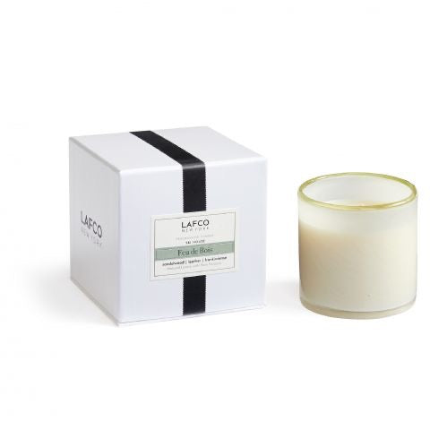 Lafco 6.5oz home candle with a sleek glass jar and a burning wick, emitting soft warm light.