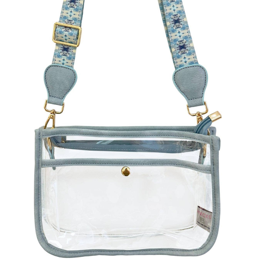 Clear stadium bag accessory by Laura Park Designs featuring transparent material with black trim and adjustable straps.