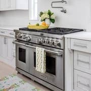 Dogwood Tea Towel by Laura Park Designs featuring a floral pattern, displayed on a kitchen countertop.