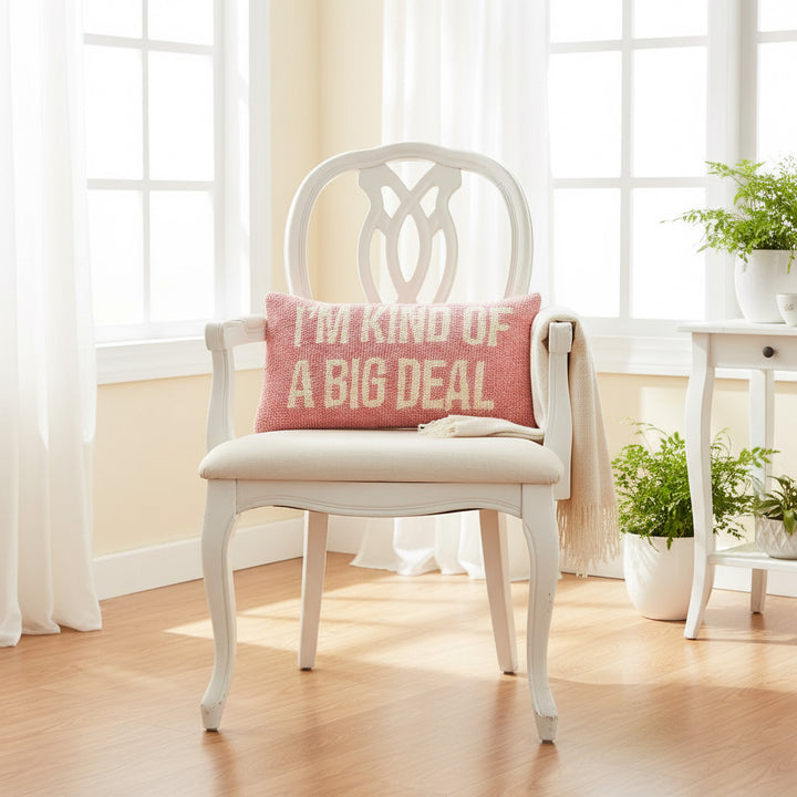 Pink pillow with 'I'm kind of a big deal' text on a gray couch