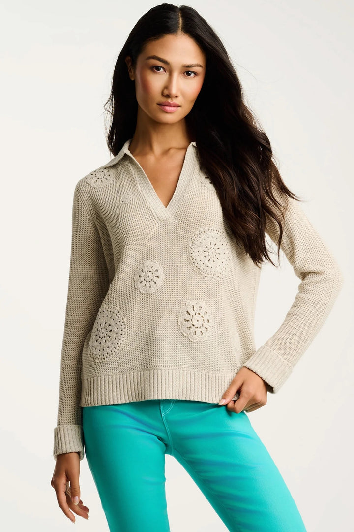 beige crochet v-neck sweater with aqua teal pants on cream background