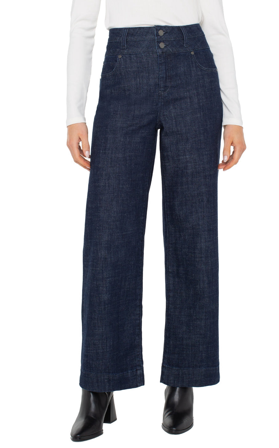 Person wearing dark blue wide-leg jeans on a white background