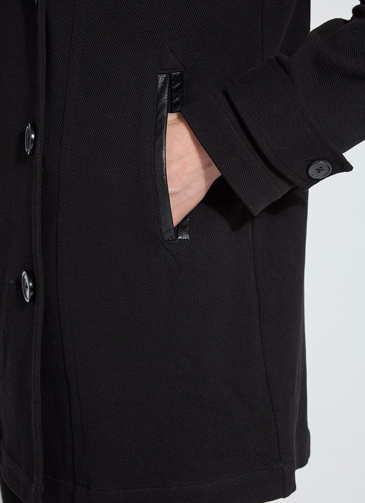 Close-up of a black coat with buttons on a light gray background