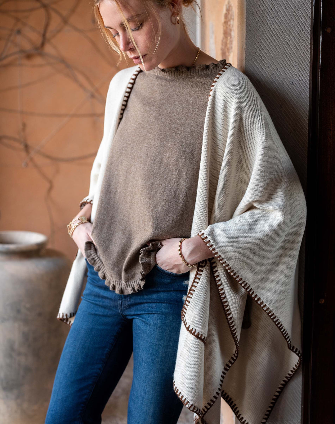 Mer-sea whipstitch cream travel wrap, soft accessories with detailed stitching, draped elegantly over a neutral background.