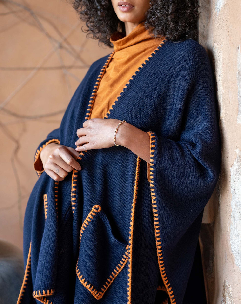 Navy travel wrap with whipstitch detailing from mer-sea, shown folded and draped for versatile travel accessories.