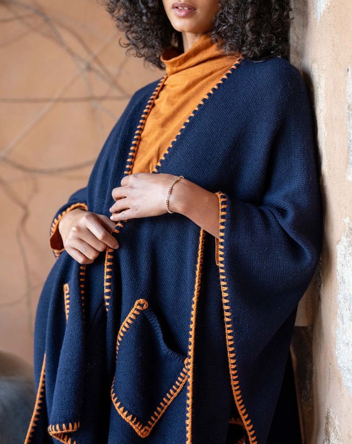 Navy travel wrap with whipstitch detailing from mer-sea, shown folded and draped for versatile travel accessories.