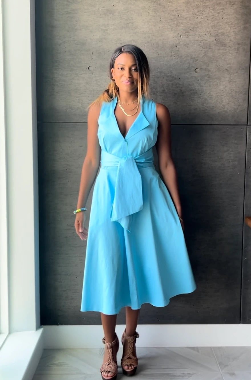 Rainment Hermosa Cove Dress displayed on a hanger, featuring a flowy fabric with vibrant colors and a stylish neckline.