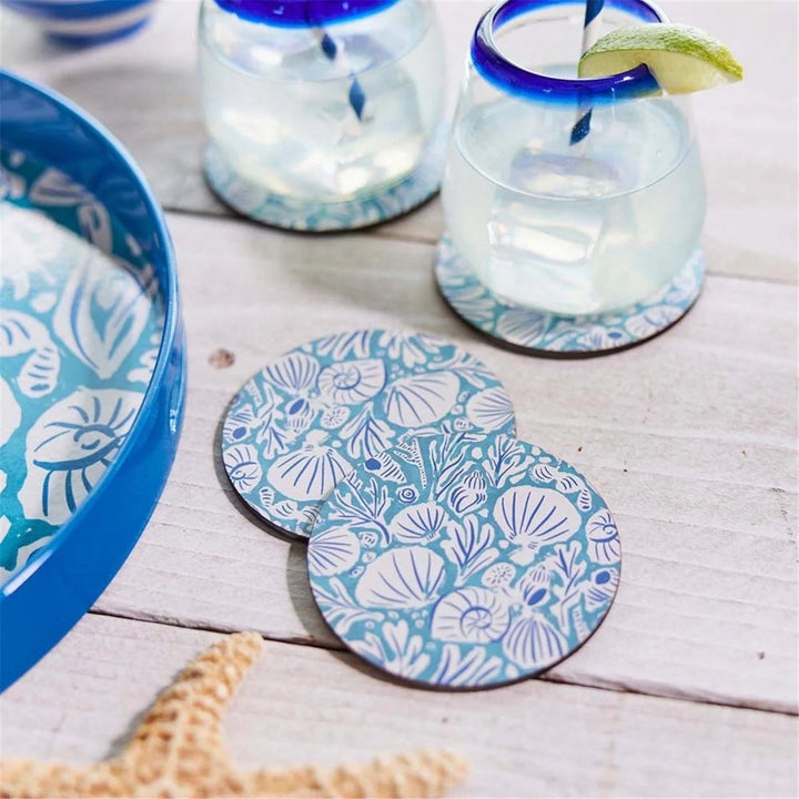 Set of four Rockflowerpaper home coasters with colorful, artistic designs, placed on a wooden table.
