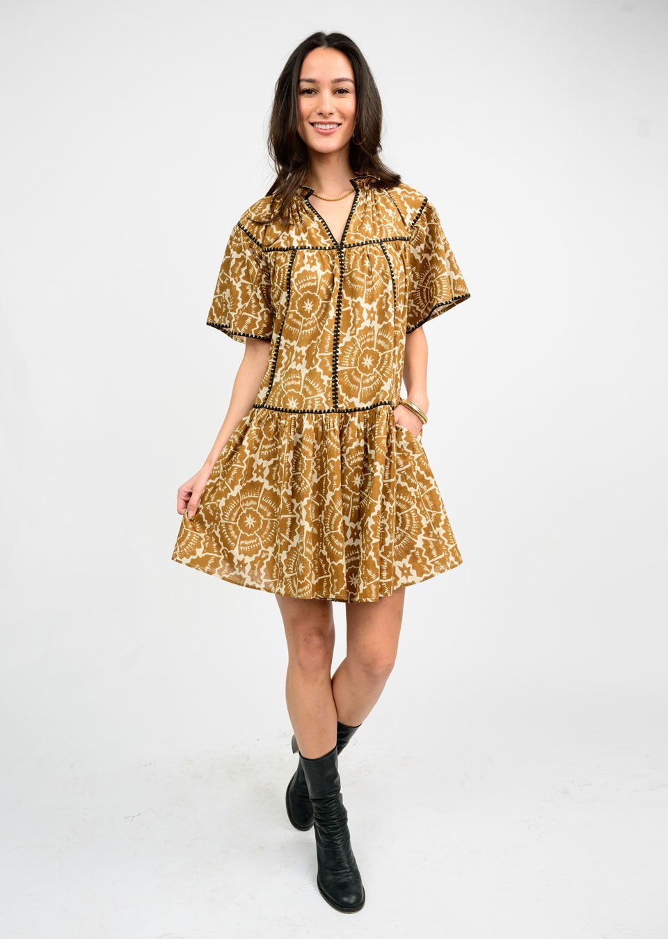 Brown stitched-trim dress by Sister Mary featuring a stylish design, displayed on a hanger with a simple background.