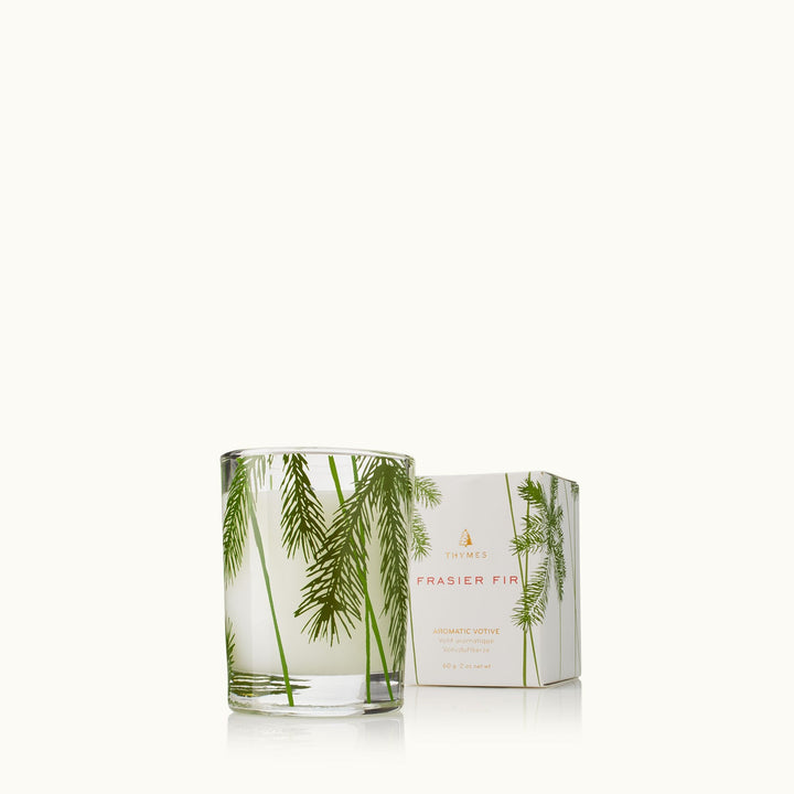 Thymes Pine Needle Votive Candle with a glass holder, featuring a fresh, forest-inspired scent and natural pine needle design.