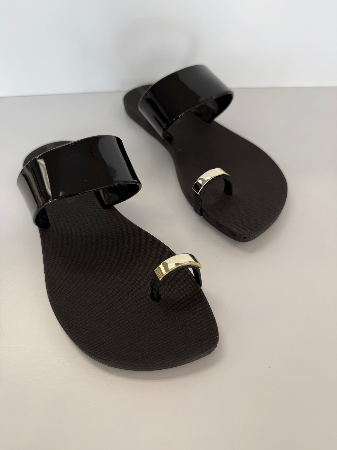 Voices Anello black and gold sandal, stylish accessories with a sleek design, featuring black straps and gold accents.
