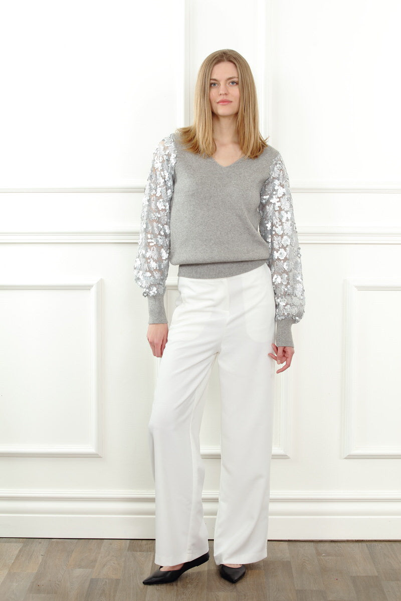 Grey sheer sequin sleeve sweater by Zero Degrees Celsius Inc, featuring lightweight knit with sparkly sequin sleeves.