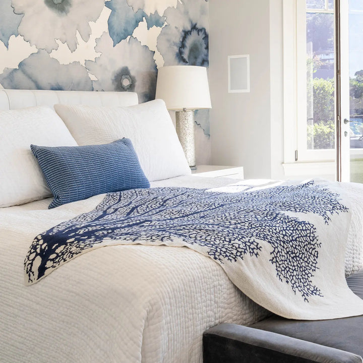 Soft coral throw blanket from In2Green, cozy home accessory with textured fabric, perfect for adding warmth and color to living spaces.