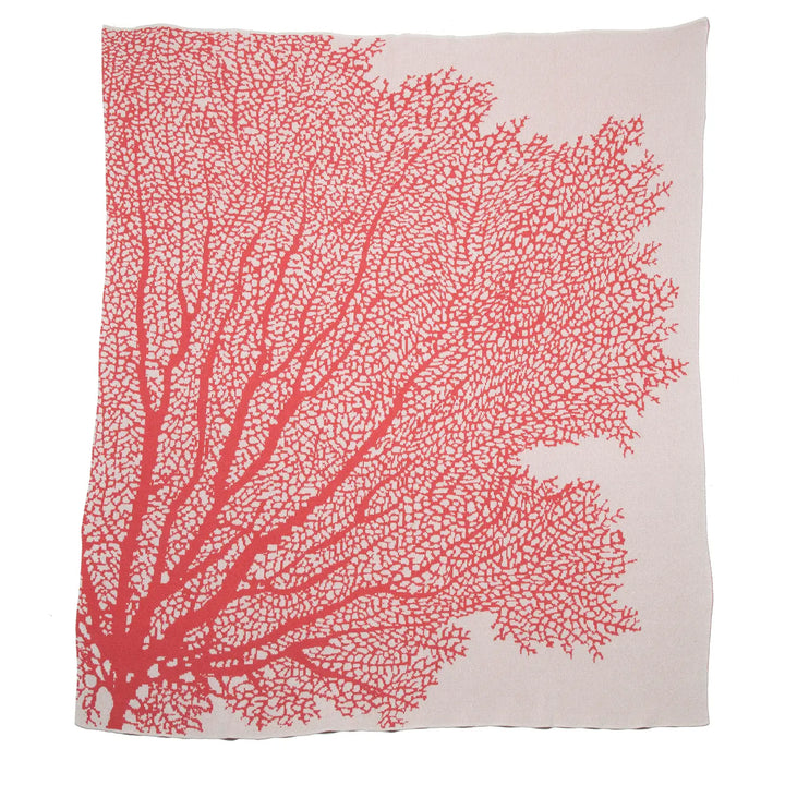 In2Green coral throw blanket draped over a cozy armchair, soft textured home decor accent for living room or bedroom.